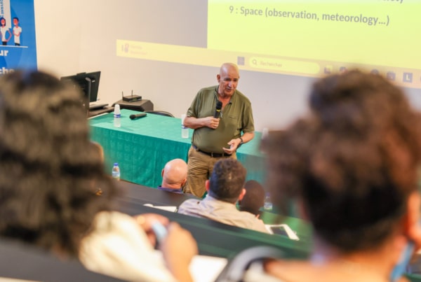 Conférence COP30 à l’Université de Guyane : intervenant face à l’auditoire dans un amphi avec vidéoprojection