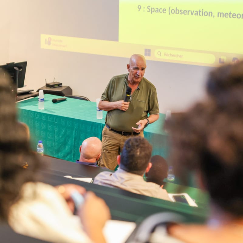 Conférence COP30 à l’Université de Guyane : intervenant face à l’auditoire dans un amphi avec vidéoprojection