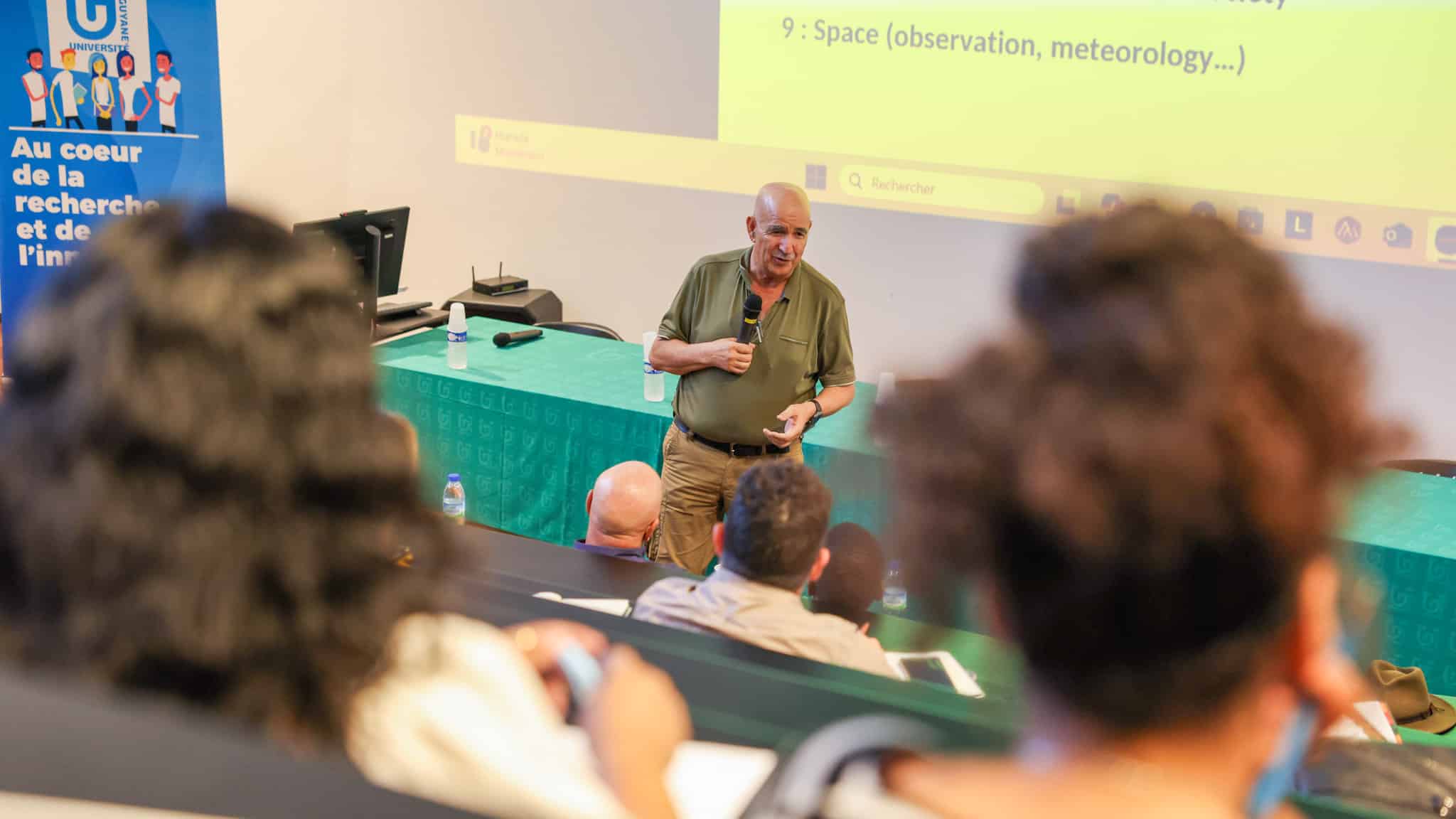 Conférence COP30 à l’Université de Guyane : intervenant face à l’auditoire dans un amphi avec vidéoprojection