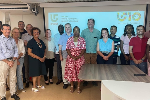 Photo de groupe lors de l’élection du premier doyen de la Faculté des Sciences Médicales et de la Santé à l’Université de Guyane, avec les membres du conseil de l’UFR réunis devant un écran de présentation.