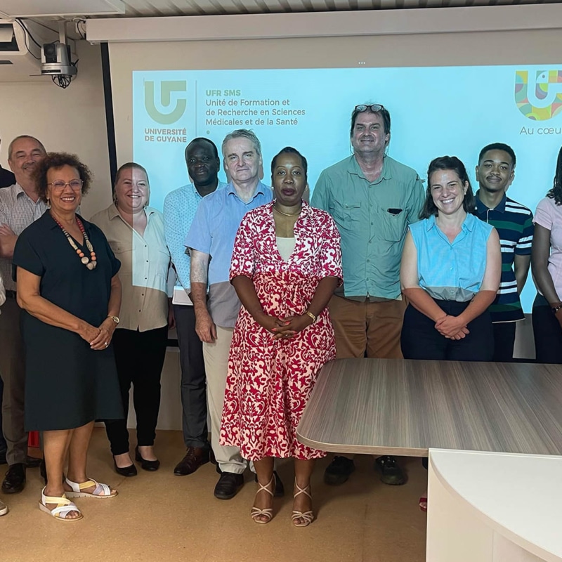 Photo de groupe lors de l’élection du premier doyen de la Faculté des Sciences Médicales et de la Santé à l’Université de Guyane, avec les membres du conseil de l’UFR réunis devant un écran de présentation.