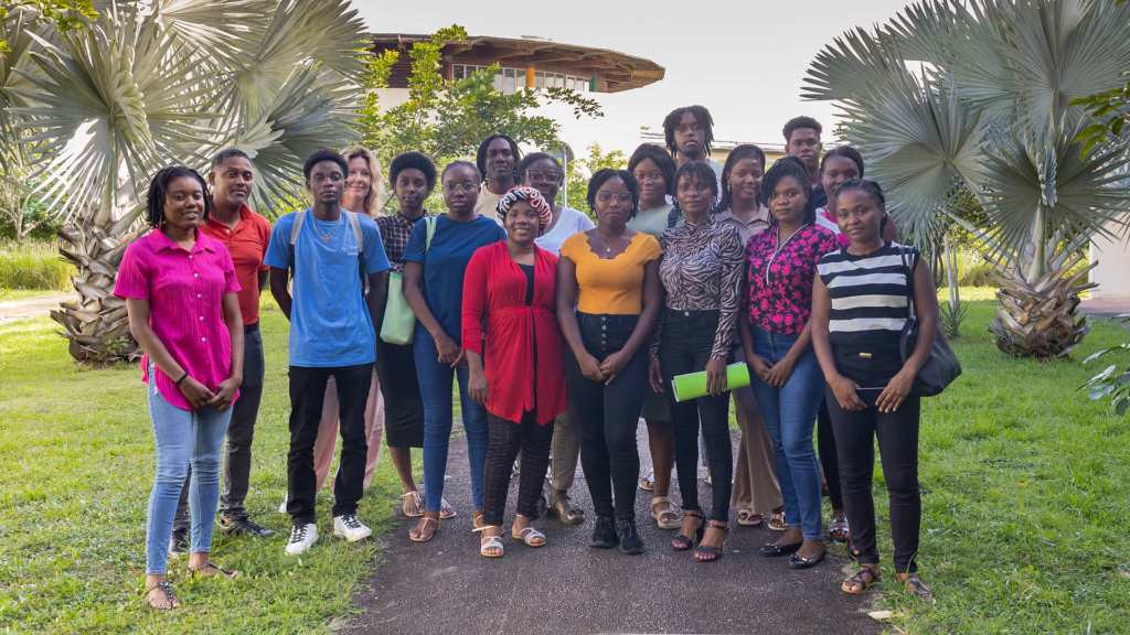 Groupe d’étudiants et formateurs de l’Université de Guyane, réunis à l’extérieur sur le campus pour la première édition du programme PREP’Alternance, souriants et debout devant des palmiers.