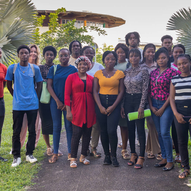 Groupe d’étudiants et formateurs de l’Université de Guyane, réunis à l’extérieur sur le campus pour la première édition du programme PREP’Alternance, souriants et debout devant des palmiers.